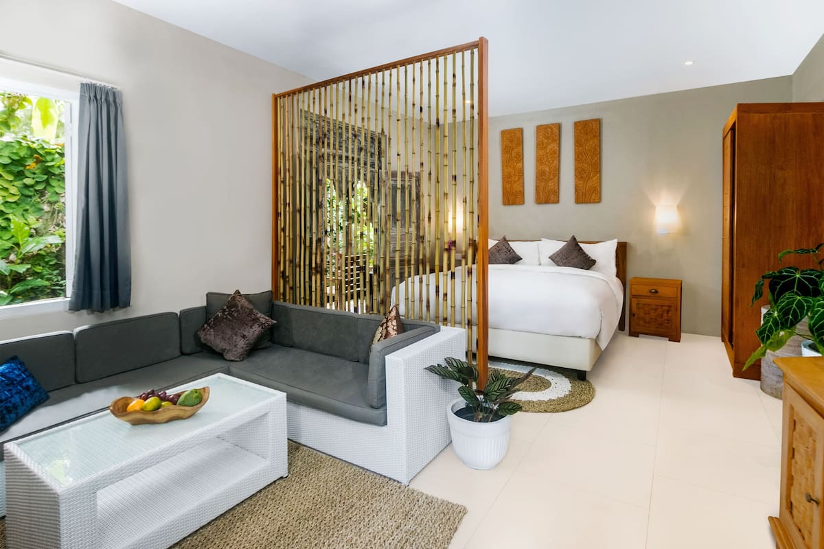 Un dormitorio moderno con cama, sofá y mesa de comedor.