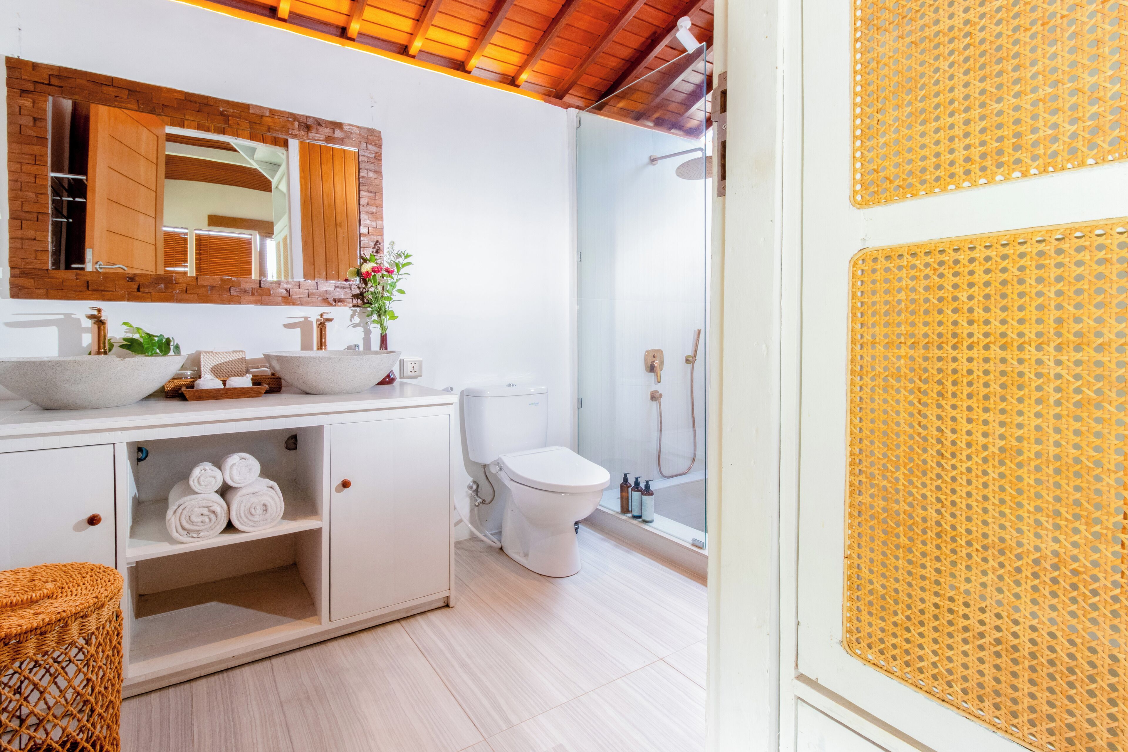 Une salle de bain moderne avec un meuble-lavabo blanc, un grand miroir et un espace douche.