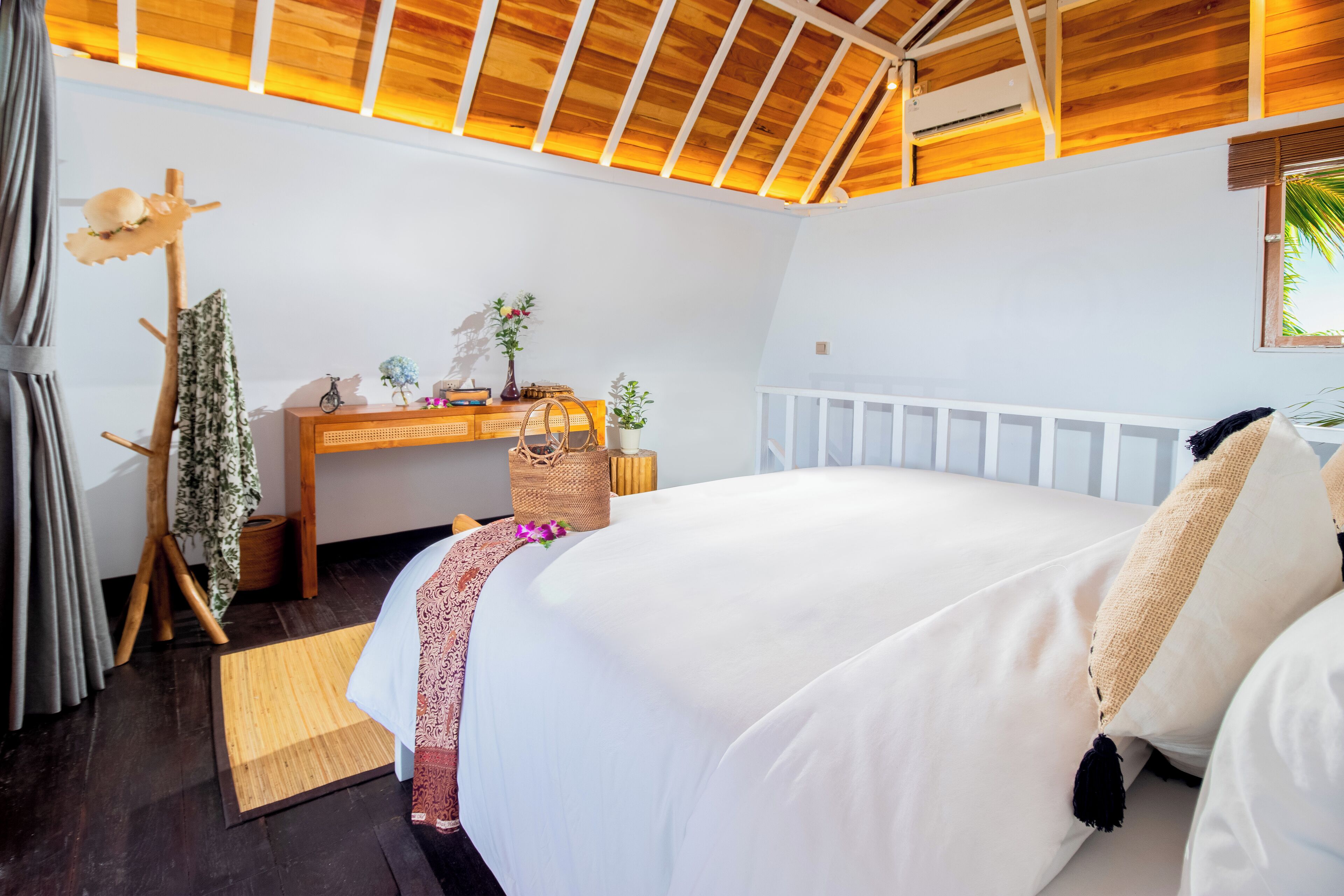 A bedroom with a bed, a desk, a chair, a window, and a ceiling fan.