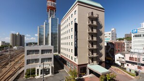 A hotel with multiple floors, a green roof, and a visible sign for the hotel. - JR East Hotel Mets Mito (Mito)