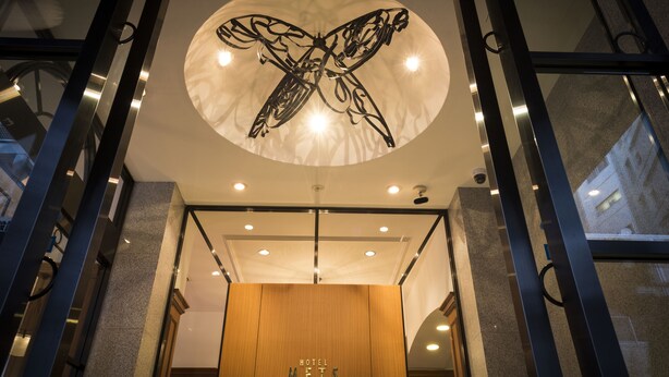 A hotel entrance with a circular ceiling design and a wooden reception desk. - JR East Hotel Mets Mito (Mito)