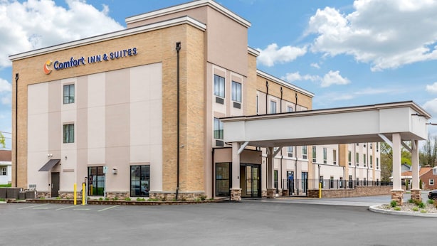 A Comfort Inn & Suites building with a brick facade, large windows, and a covered entrance area.