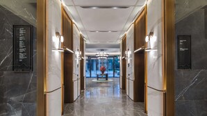A modern hotel lobby with marble floors, wooden doors, and a central seating area. - WYNDHAM WENZHOU (Wenzhou)