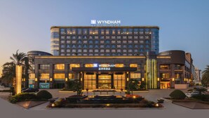A Wyndham hotel with a modern design, featuring a prominent entrance and a well-lit facade. - WYNDHAM WENZHOU (Wenzhou)