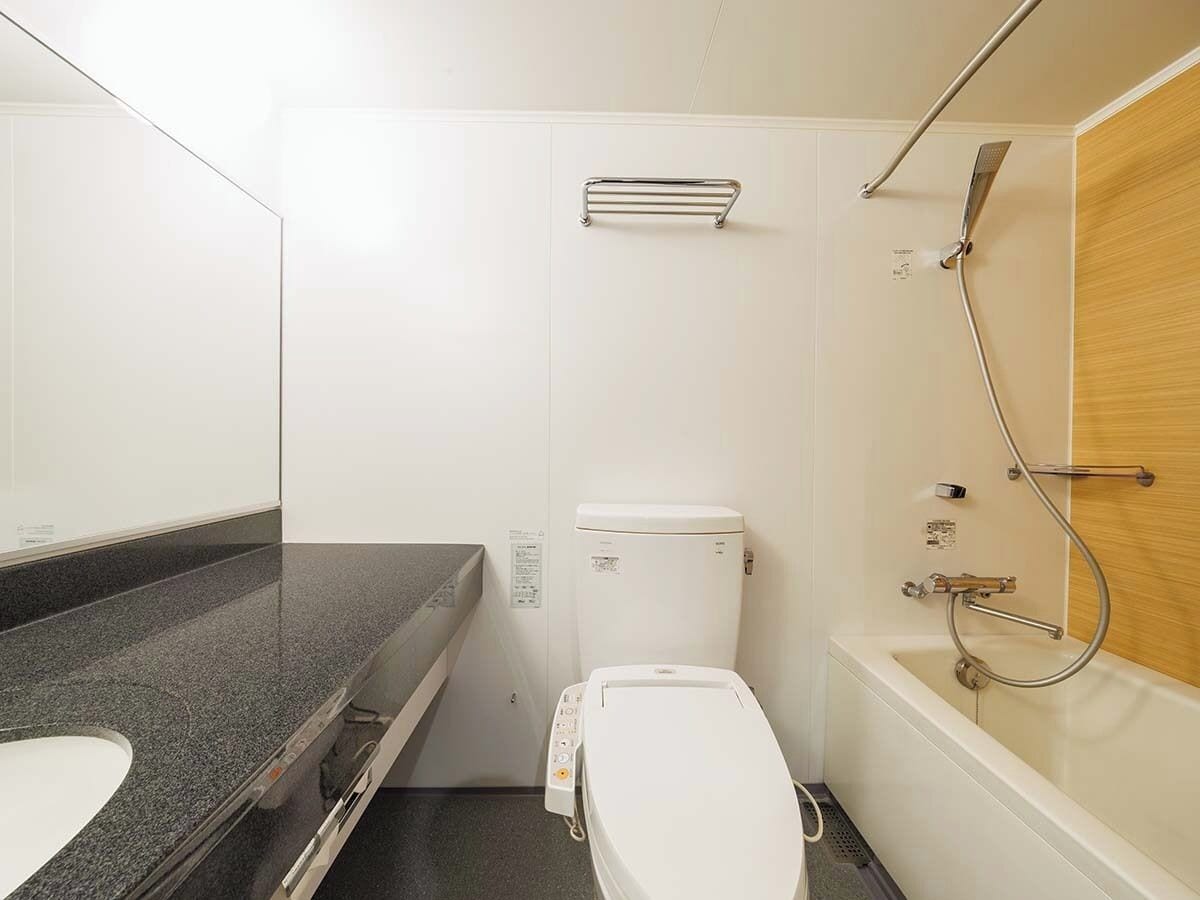 A bathroom with a toilet, sink, shower, and bathtub.