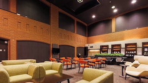 A lobby with seating areas, a reception desk, and a wall with framed items.