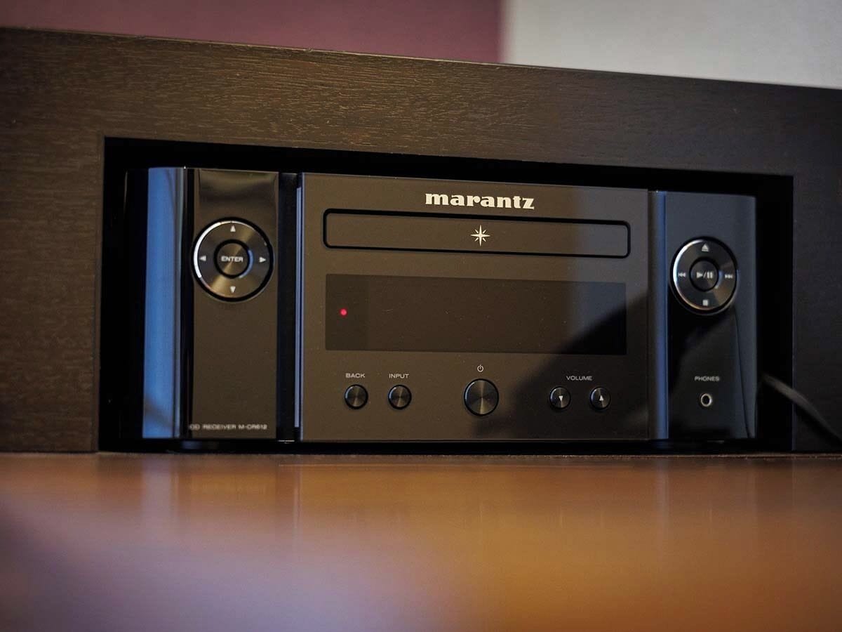 Un récepteur audio Marantz doté d’un écran, de boutons de commande et d’un boîtier pour haut-parleur.