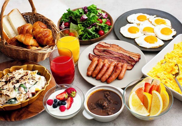A breakfast spread with croissants, sausages, eggs, and various fruits and beverages. - JR East Hotel Mets Utsunomiya (Utsunomiya)