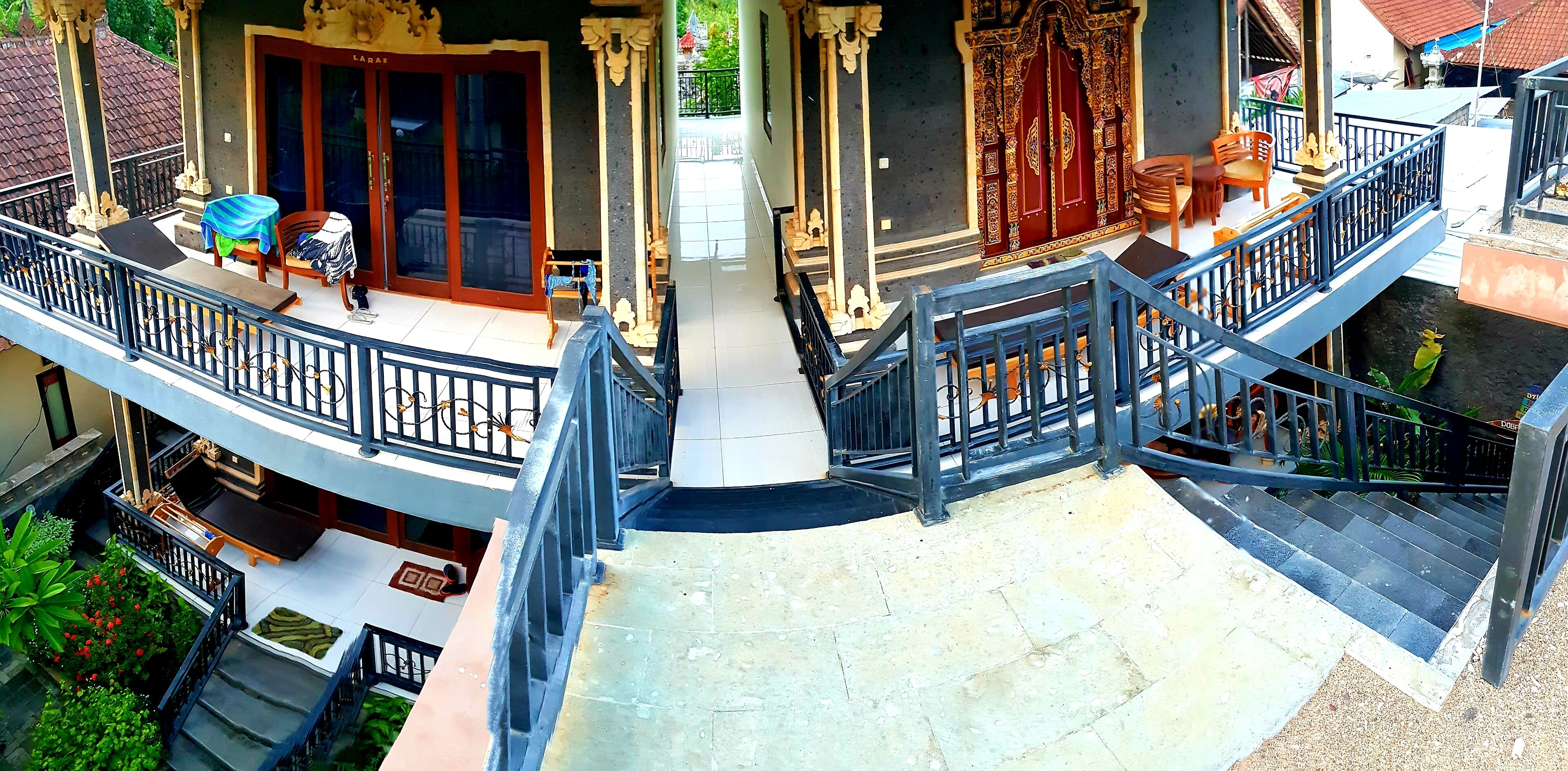 A multi-level building with a balcony, stairs, and a door with intricate designs.