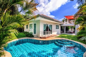 A modern house with a swimming pool, surrounded by lush greenery and a clear blue sky. - Leelawadee Pool Villa (Sattahip)