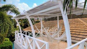 A covered outdoor area with a hammock and a white railing. - Leelawadee Pool Villa (Sattahip)