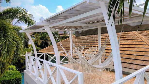 A covered outdoor area with a hammock and a white railing. - Leelawadee Pool Villa (Sattahip)