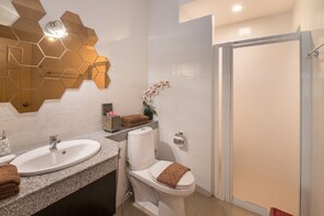 Een moderne badkamer met twee wasbakken, een toilet en een douche.