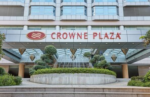 The exterior of Crowne Plaza hotel with a modern architectural design, a central water feature, and a landscaped area with greenery. - Crowne Plaza Zhongshan Wing on City (Zhongshan)