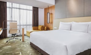 A hotel room with a large bed, a desk, a chair, and a sofa. - Crowne Plaza Zhongshan Wing on City (Zhongshan)