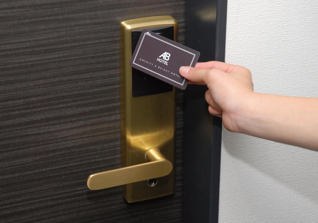 A hand inserting a card into a hotel door lock.