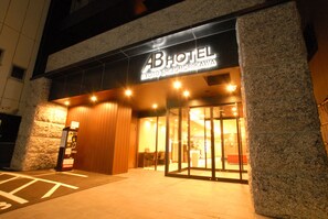 The exterior of ABHOTEL with a modern design, featuring a stone facade and a glass entrance. - AB Hotel Kyoto Shijo Horikawa (Kyoto)