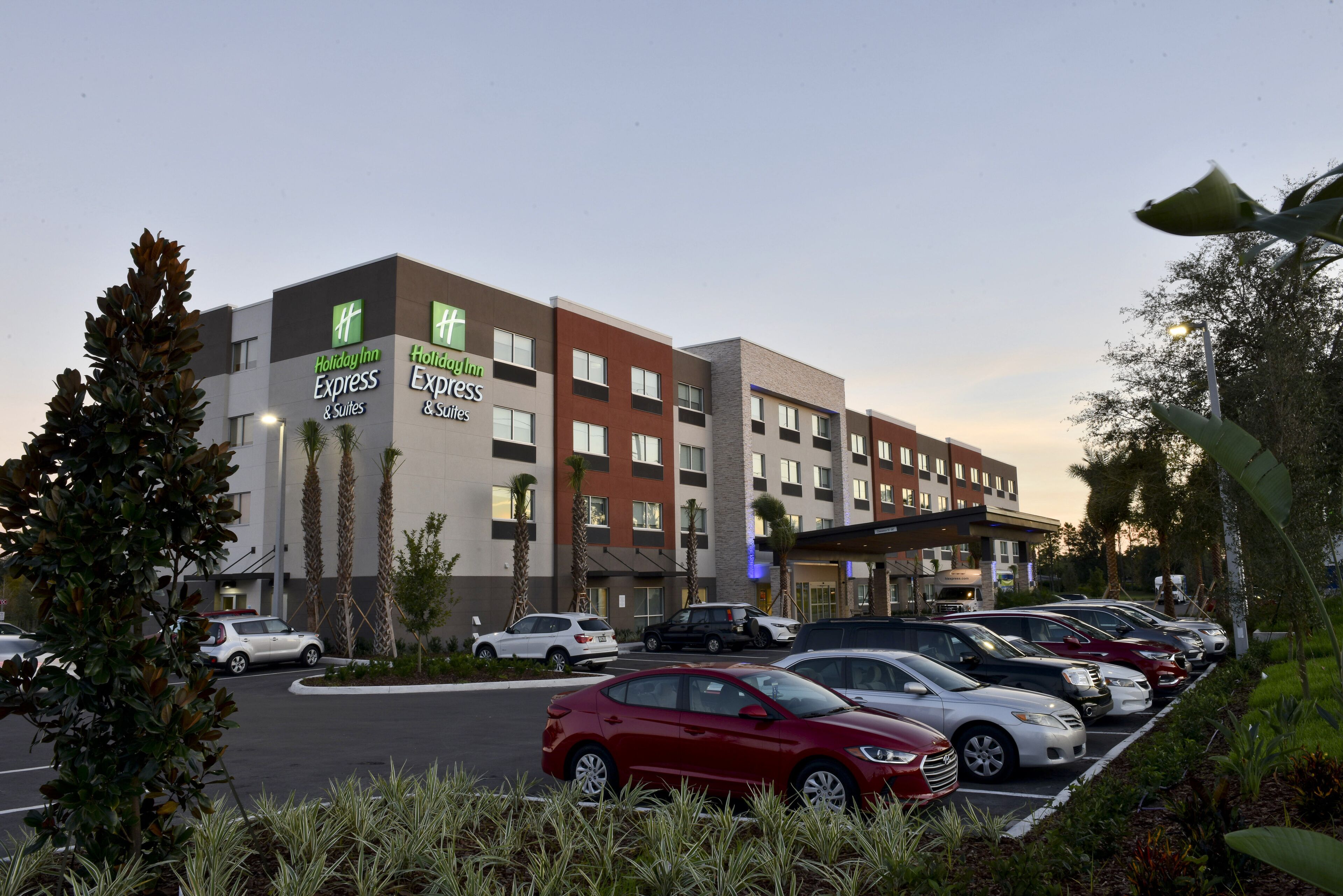 A Holiday Inn Express building with multiple floors, parking lot, and several cars parked in front.