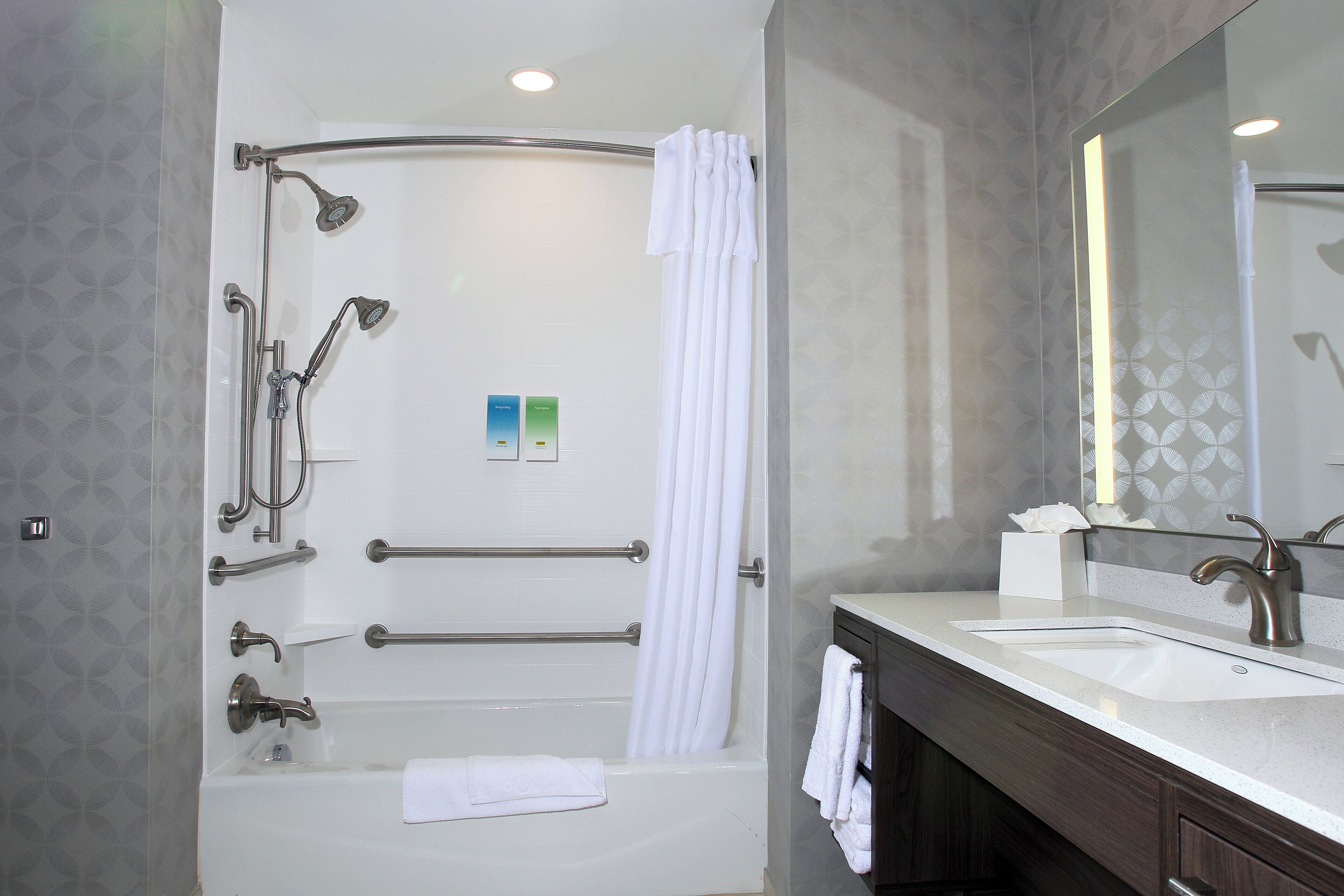 Une salle de bain moderne équipée d’une baignoire, d’une douche et d’un meuble-lavabo avec un évier.