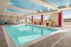 Una piscina techada, sillones reclinables de piscina
