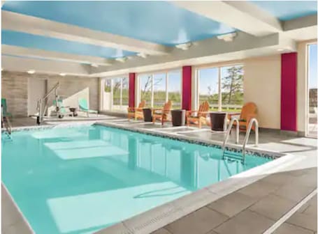 Una piscina techada, sillones reclinables de piscina