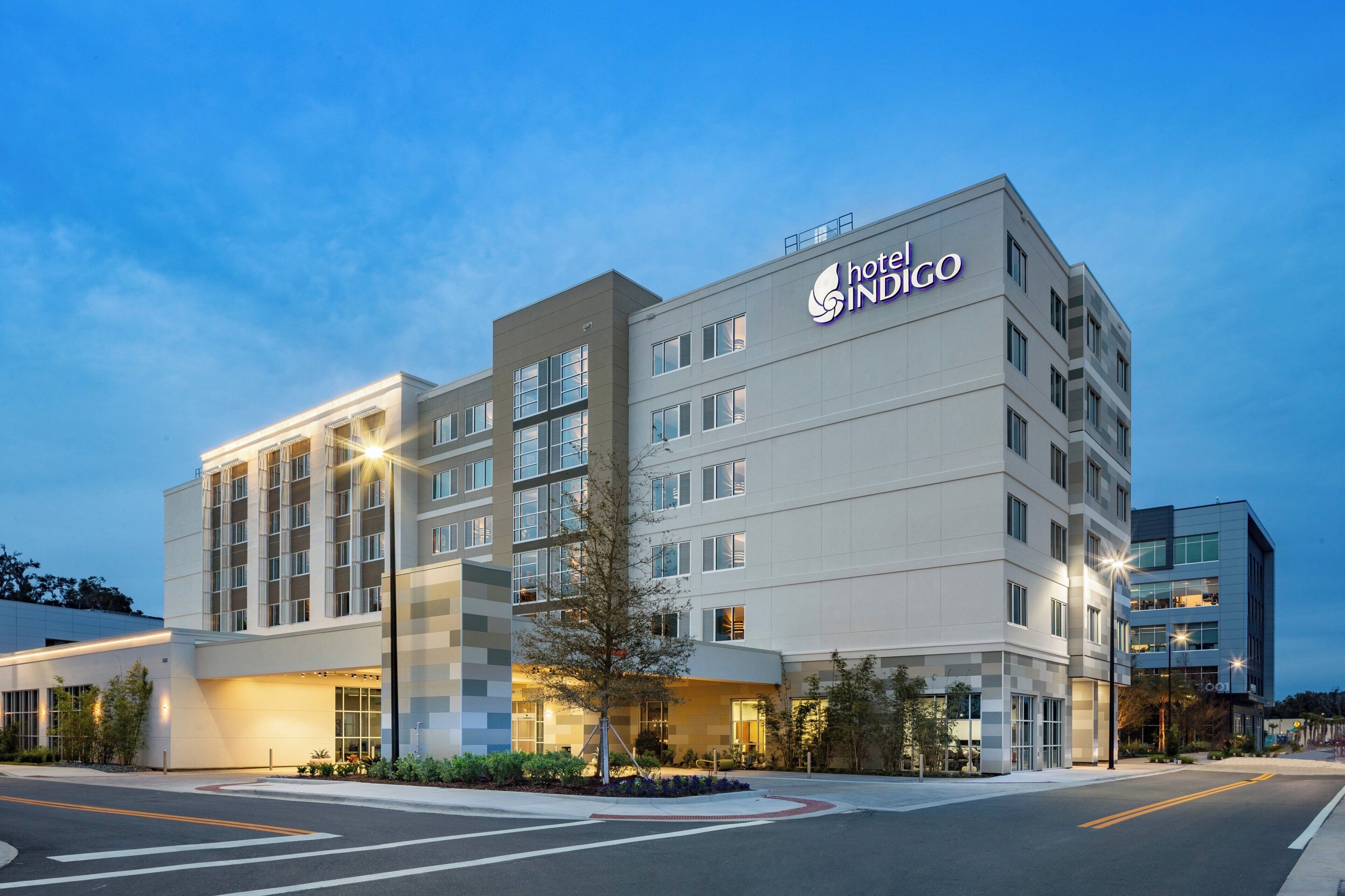 A hotel building with multiple floors, large windows, and a prominent hotel name on the facade.