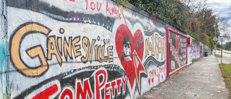 Un mur couvert de graffitis, sur lequel on peut notamment lire les mots « Gainesville » et « Tom Petty ».