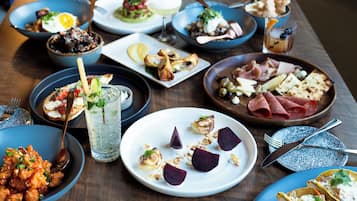 Verschiedene Speisen auf einem Tisch, darunter Salate, Fleischgerichte und Desserts.