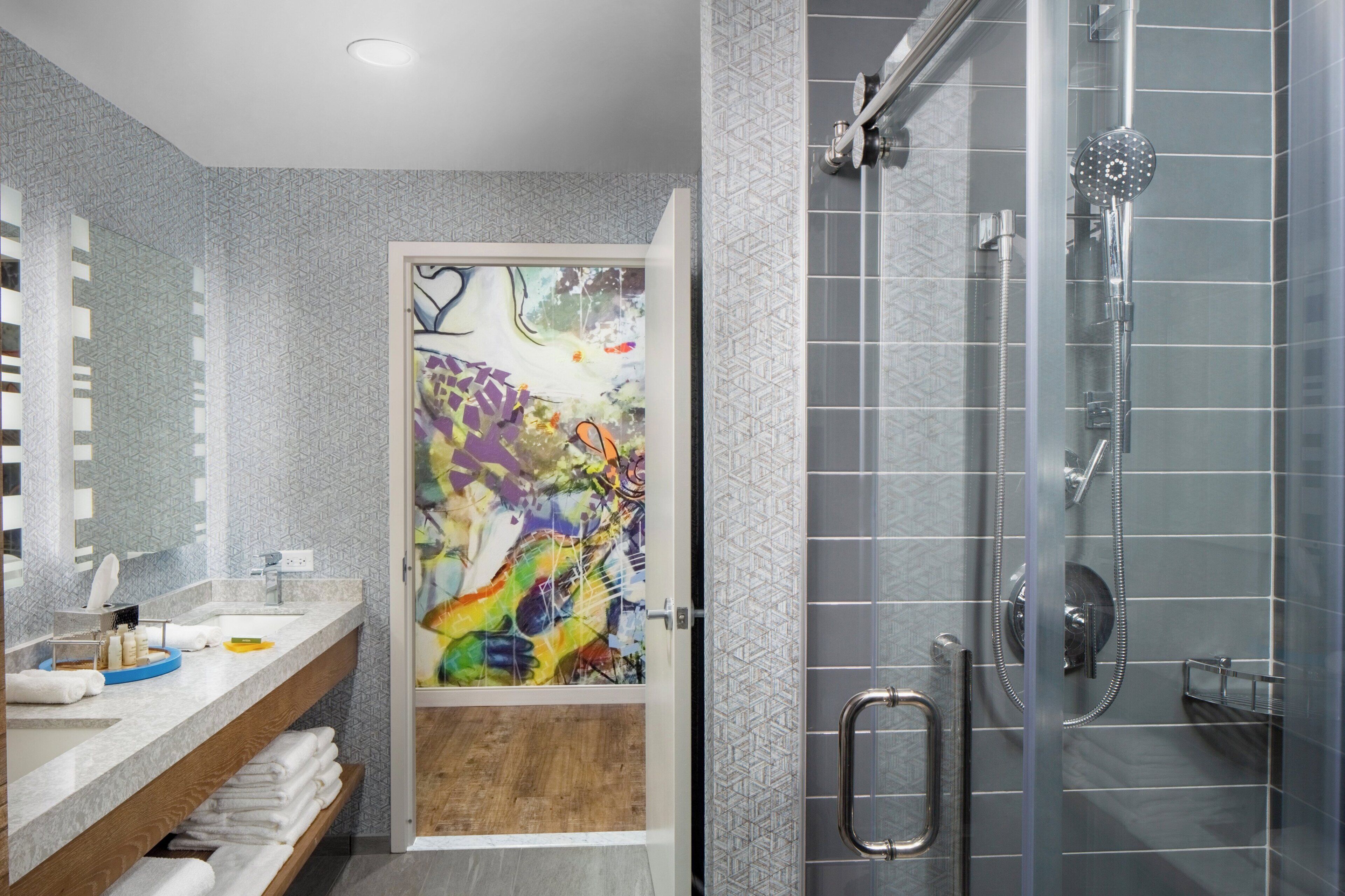 A modern bathroom with a shower, a sink with a mirror, and a towel rack.