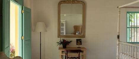 A room with a wooden desk, a mirror, a lamp, and a chair.