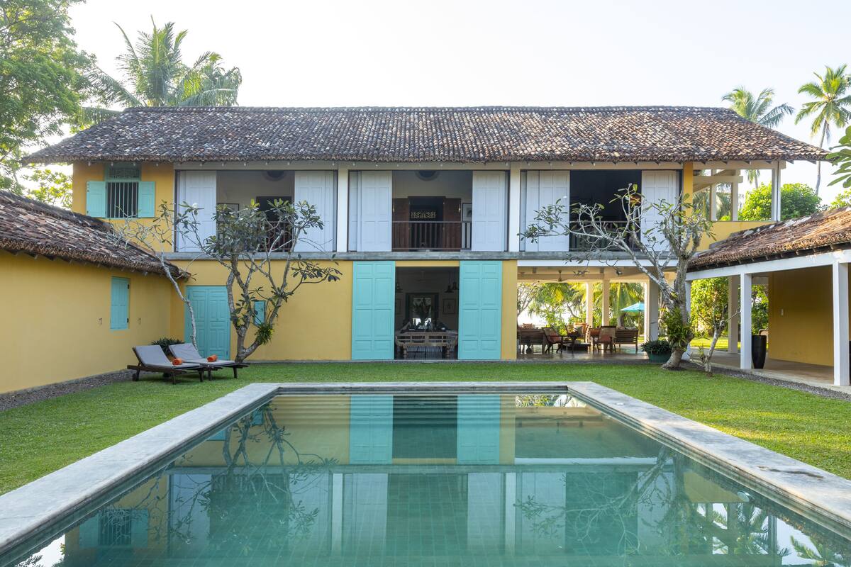 A two-story building with a swimming pool in the foreground.