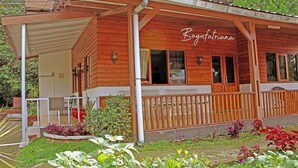 Une cabane en bois dotée d’un porche abrité et d’un jardin.
