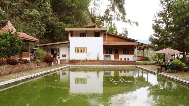 Un bâtiment moderne à deux étages avec une piscine à l’avant.