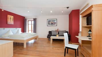 Een moderne slaapkamer met een bed, bureau, stoel en televisie.