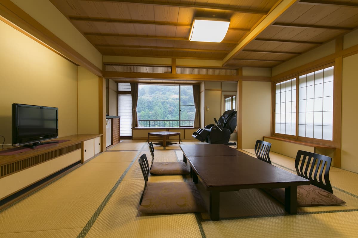 Une pièce de style japonais traditionnel, avec un sol recouvert de tatamis, une table basse et des portes coulissantes.
