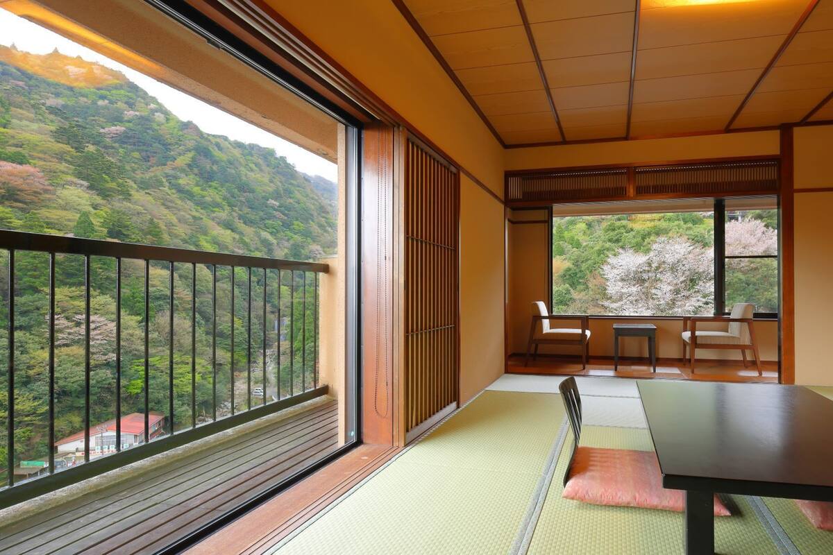 Une pièce de style japonais traditionnel, avec un sol recouvert de tatamis, une table basse et des portes coulissantes.
