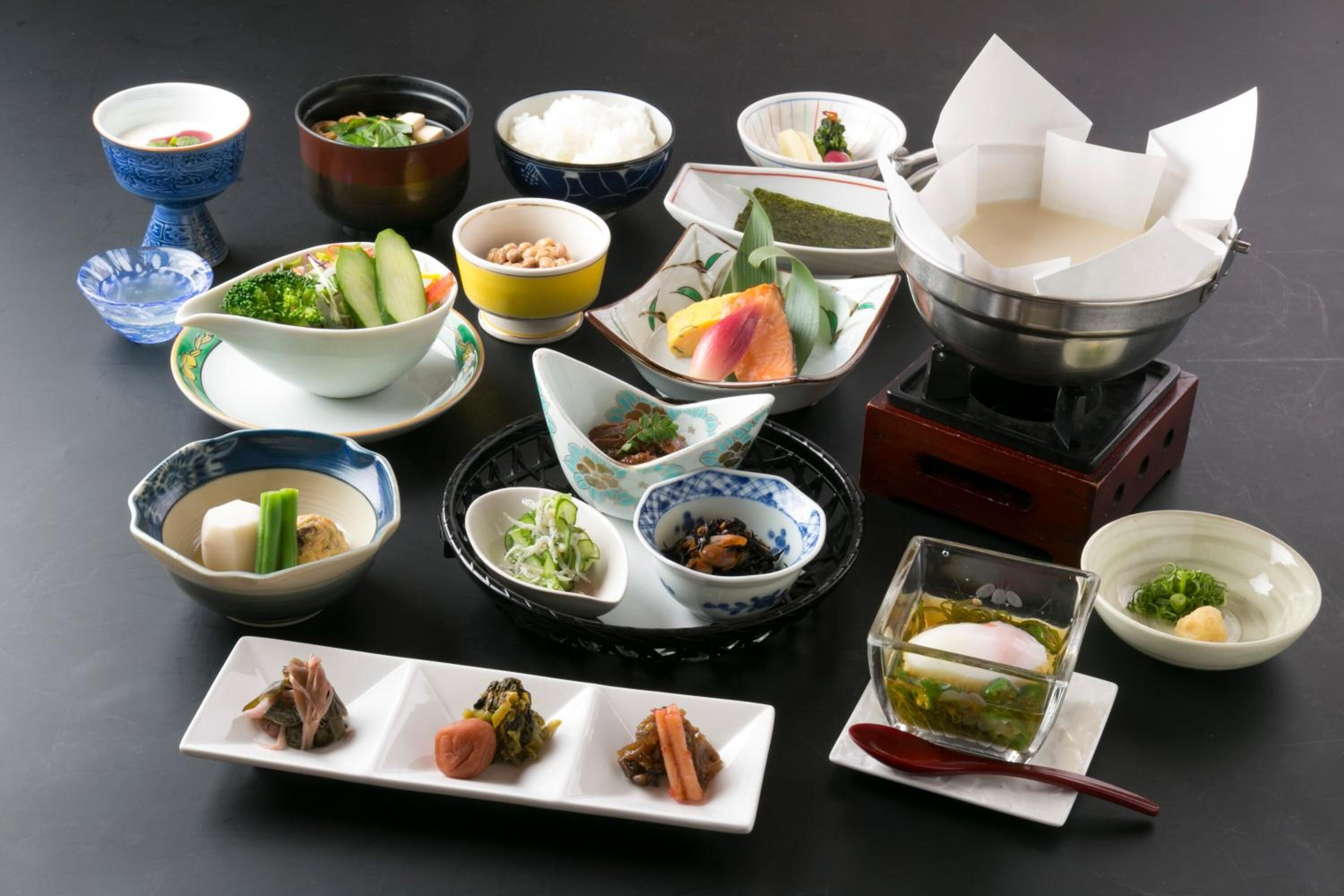 Diversos pratos japoneses dispostos sobre uma mesa, incluindo sushi, sashimi e outras iguarias tradicionais.