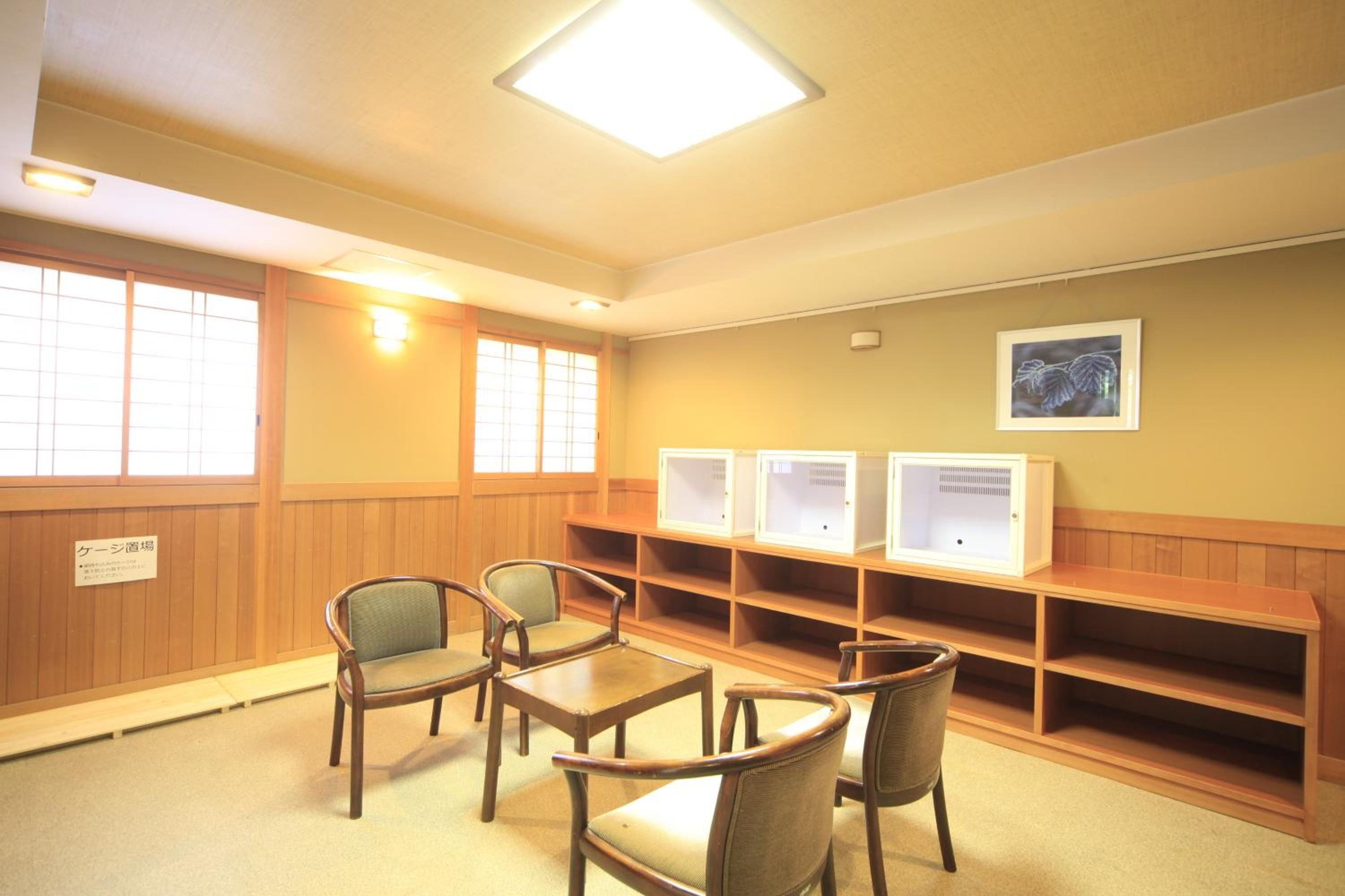 A library with wooden furniture, bookshelves, and a framed picture on the wall.