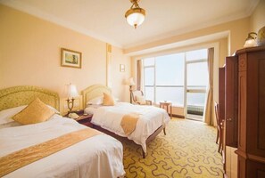 A hotel room with two beds, a large window, and a view of the sea. - Qingdao Huiquan Dynasty Hotel (QINGDAO)