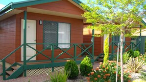 A small, single-story cabin with a porch, a door, and a window with a mesh screen. - Port Lincoln Villas (Port Lincoln)