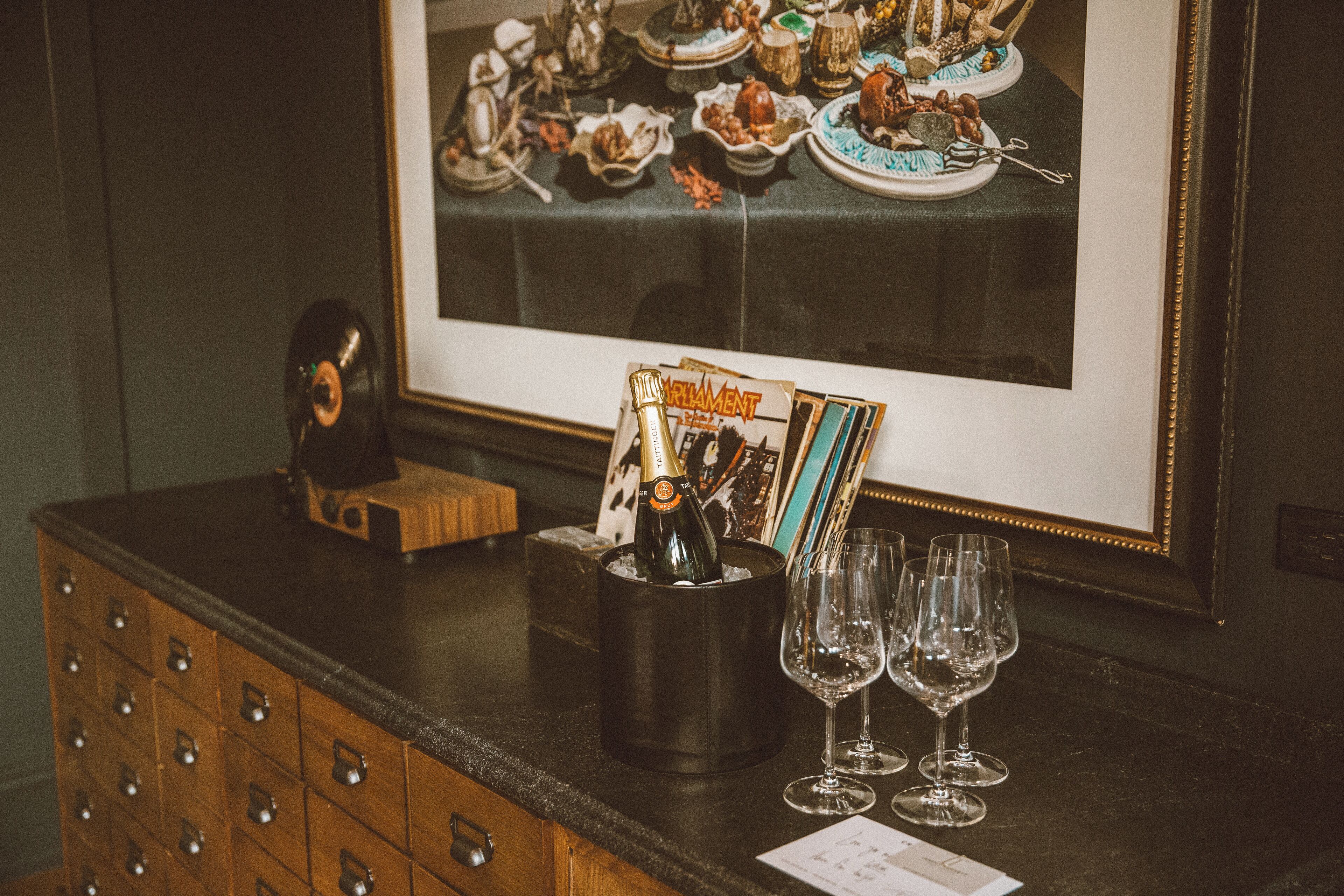 En bar med en rammeindrettet menu, en champagneflaske og glas på disken.