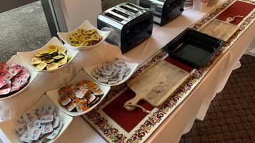 Una mesa de buffet con diversos alimentos y tostadores.