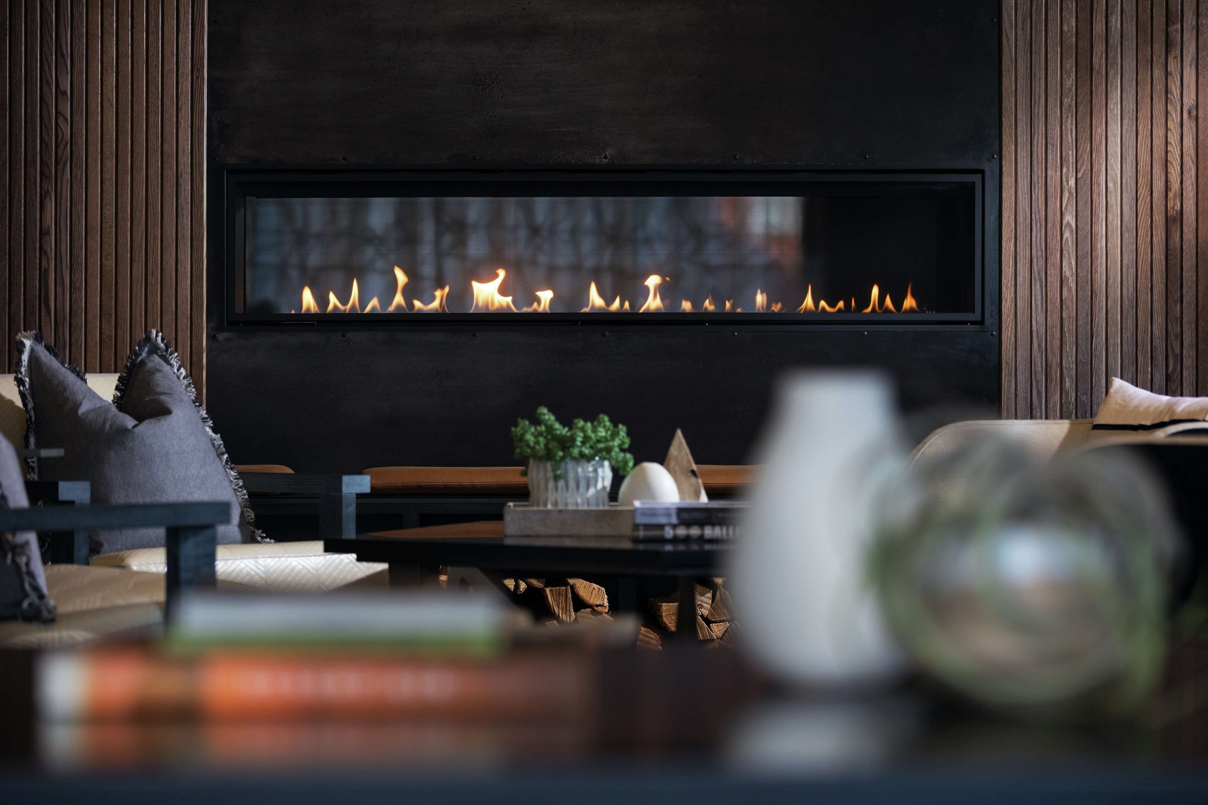 A modern living room with a fireplace, wooden furniture, and a cozy atmosphere.