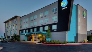 A modern hotel building with a prominent 'TRU by Hilton' sign, multiple floors, and a well-lit entrance. - TRU BY Hilton Round Rock (Round Rock)