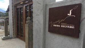 A sign for SHANGRI-LA YOU-YOU ART HOTEL with a signature and Chinese characters. - Shangri-La Youyou Inn (Deqin)
