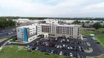 A multi-story hotel with a parking lot in front.