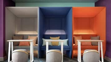 A modern living room with three distinct seating areas, each with a different color theme and a small table in front.