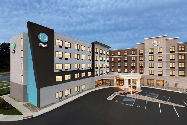 A hotel with a modern design, featuring multiple floors and a parking lot with handicapped spaces.