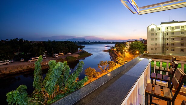 A high-rise hotel with a view of a river and distant mountains. - The Art - Big Sea Villa Hoi An Riverside (Da Nang)