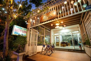 A hotel entrance with a signboard, bicycle racks, and a well-lit outdoor area. - The Art - Big Sea Villa Hoi An Riverside (Da Nang)